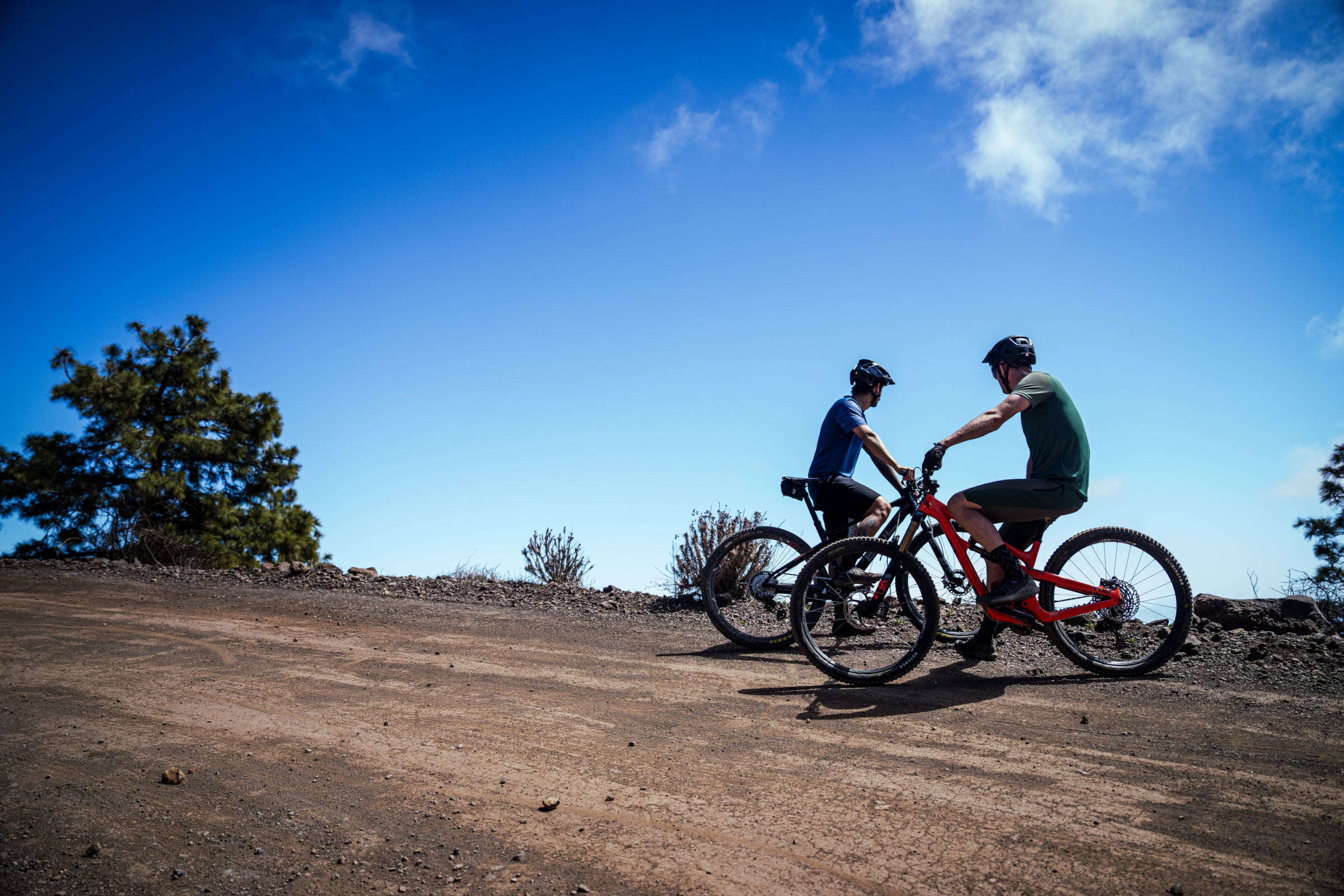 Two riders climbing trail